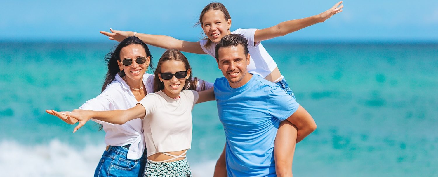 Parents with two kids have fun on the beach
