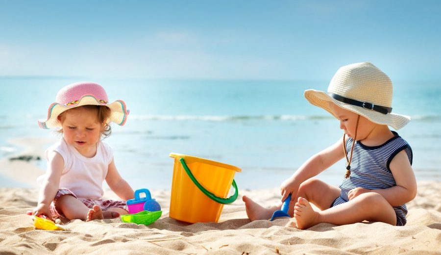 Babygirl and babyboy sitting on the beach