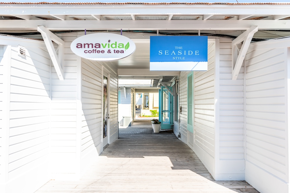 Seaside, USA - April 25, 2018: New urbanist white architecture in historic city town beach village during sunny day in Florida panhandle gulf of mexico, shopping