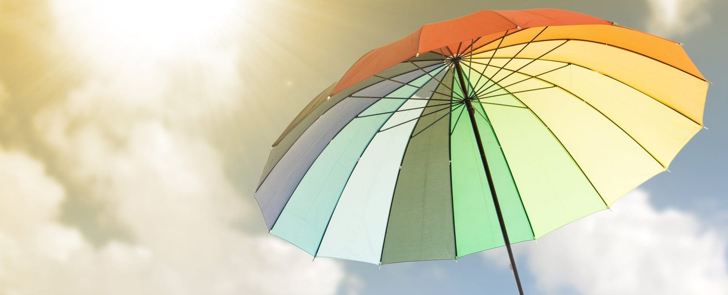 Rainbow colored umbrella; Things to Do at the Beach When it Rains