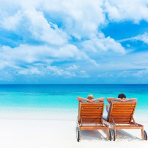 two beach chairs on beach overlooking ocean