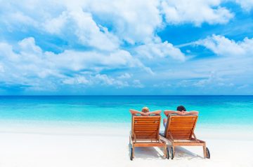 two beach chairs on beach overlooking ocean