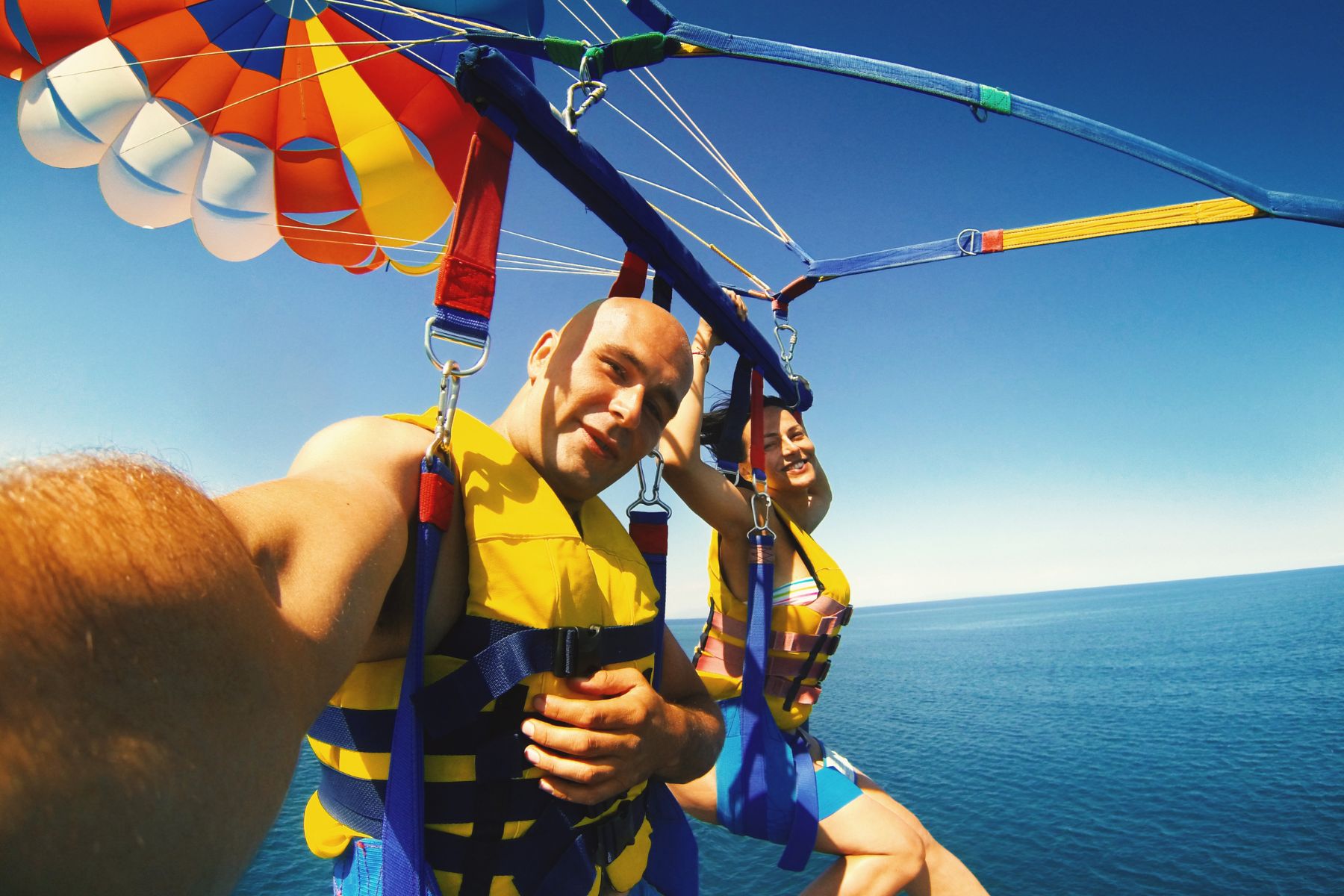 couple parasaling above destin waters