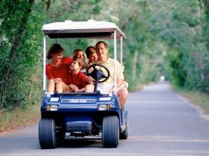 family riding in golf cart