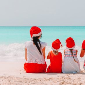 Family in Christmas hats on the beach