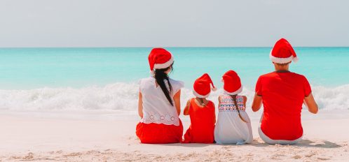 Family in Christmas hats on the beach