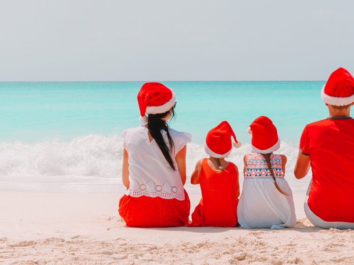 Family in Christmas hats on the beach