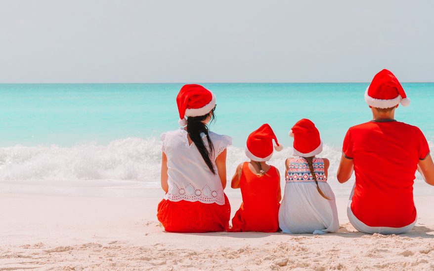Family in Christmas hats on the beach