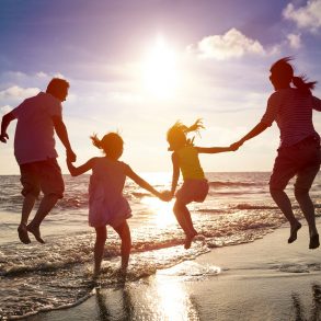 happy family jumping together on 30A beach