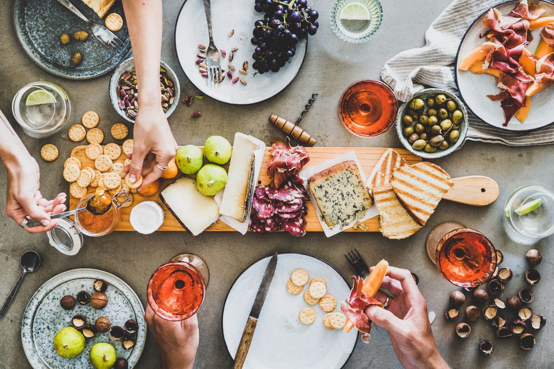 charcuterie board with friends passing around plates together
