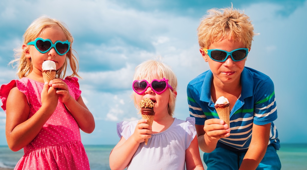 Kids eating ice cream on the beach.