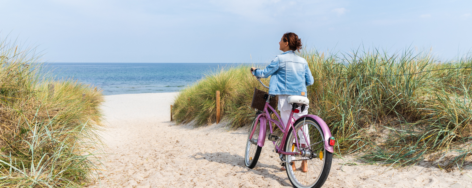 woman with bike on beach