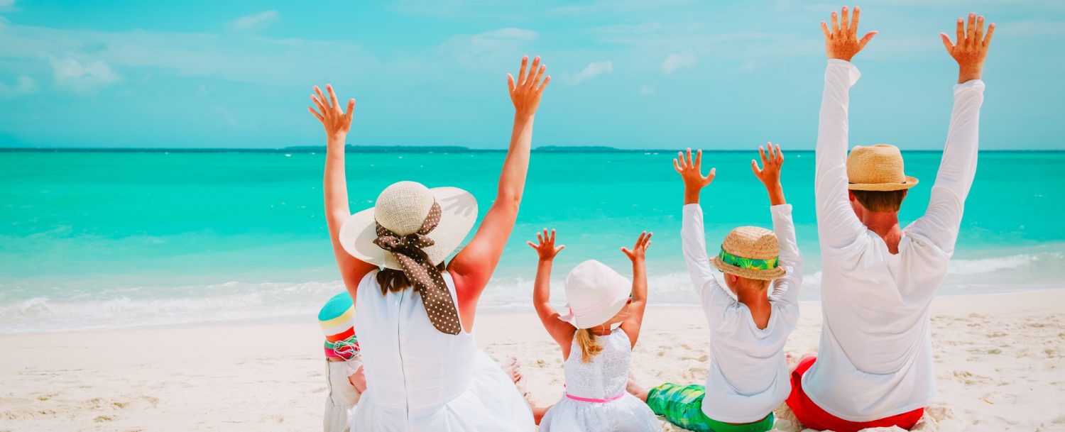 happy family with kids hands up on tropical beach