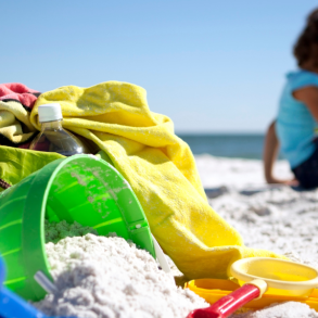 beach bag, sand toys, and little girl sitting on beach