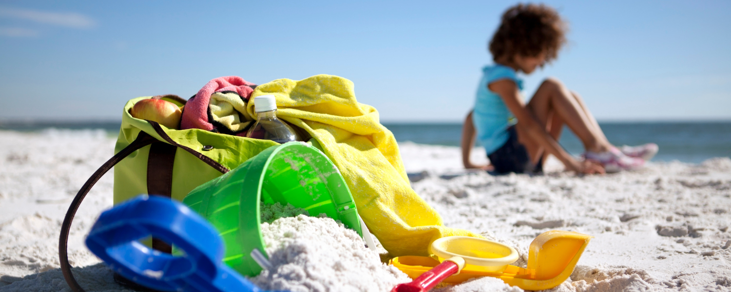 beach bag, sand toys, and little girl sitting on beach