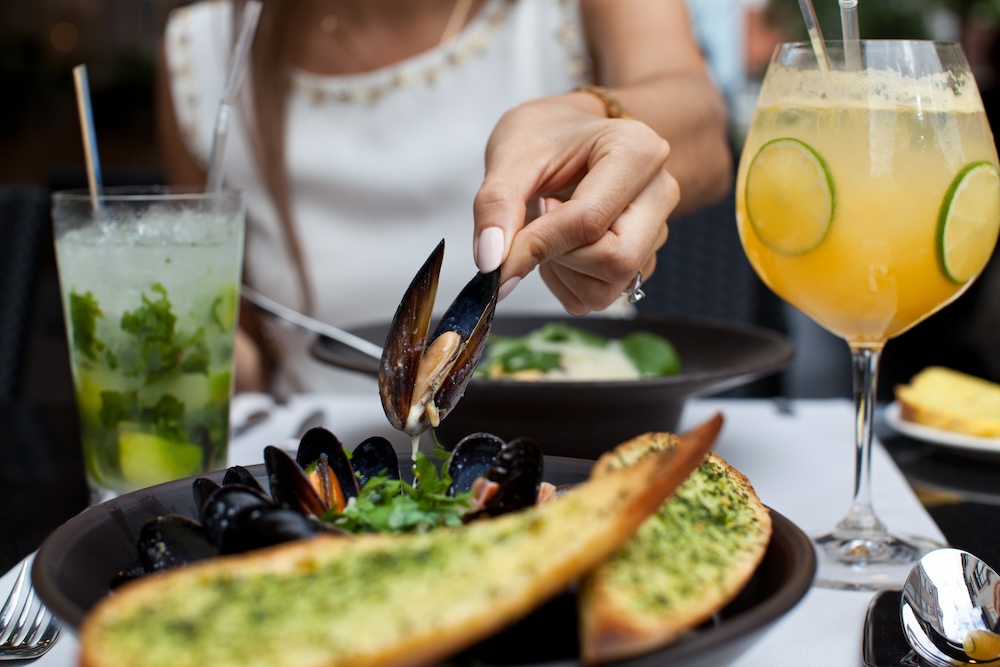Woman eating seafood in a restaurant.