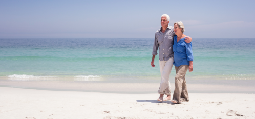 older couple walking on beach