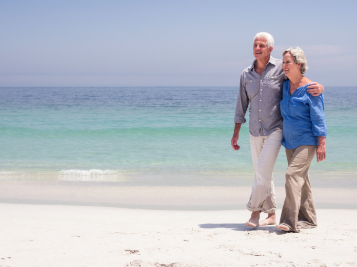 older couple walking on beach