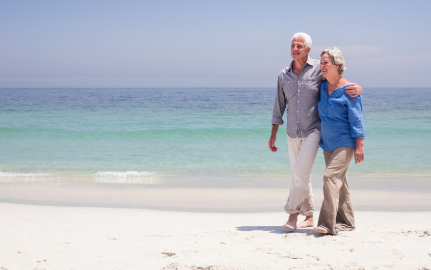 older couple walking on beach