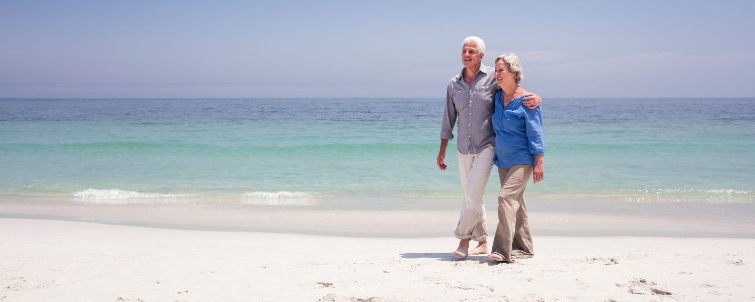 older couple walking on beach